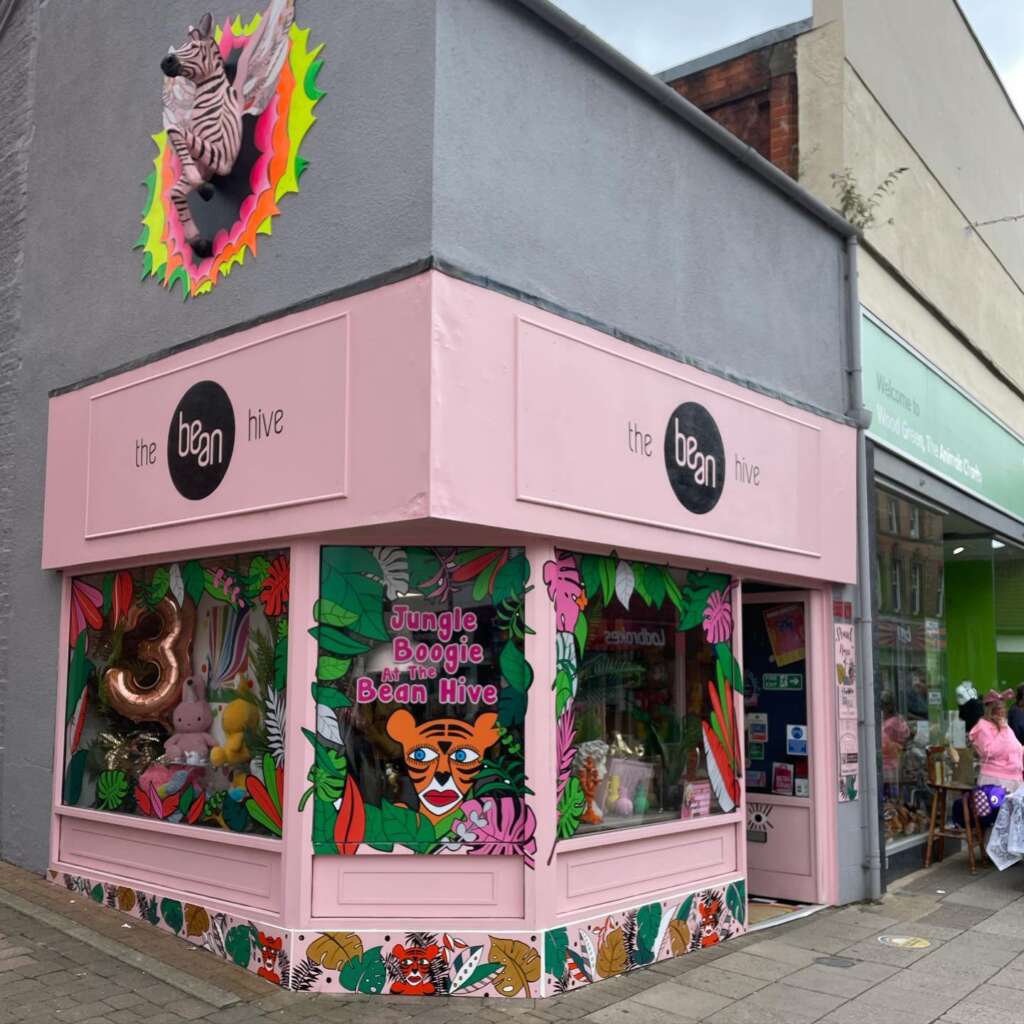 The pink Bean Hive shop front with a the front half of a zebra with wings emerging from the wall above